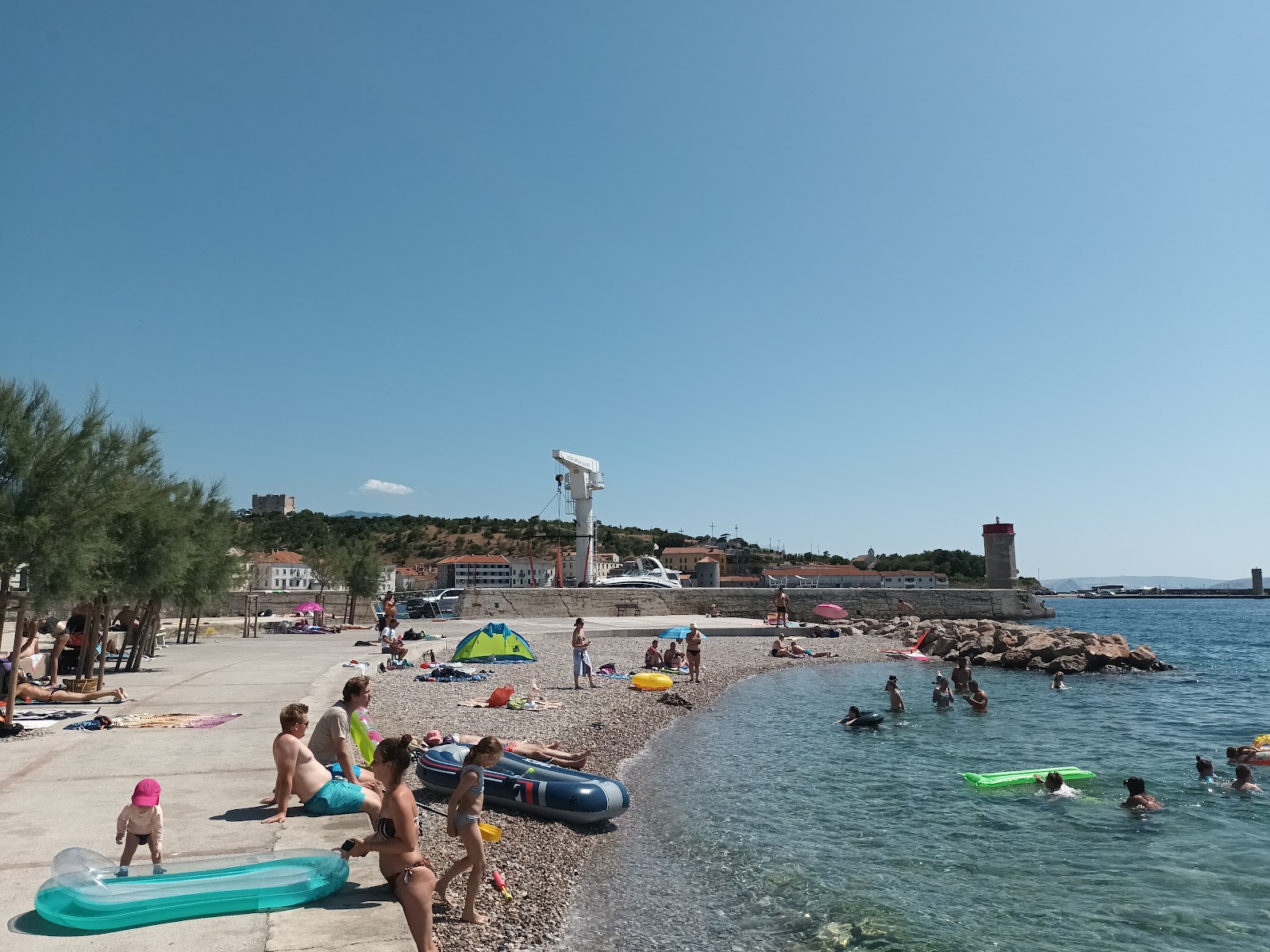 Foto di Plaza Senj con una superficie del sabbia grigia e ciottoli