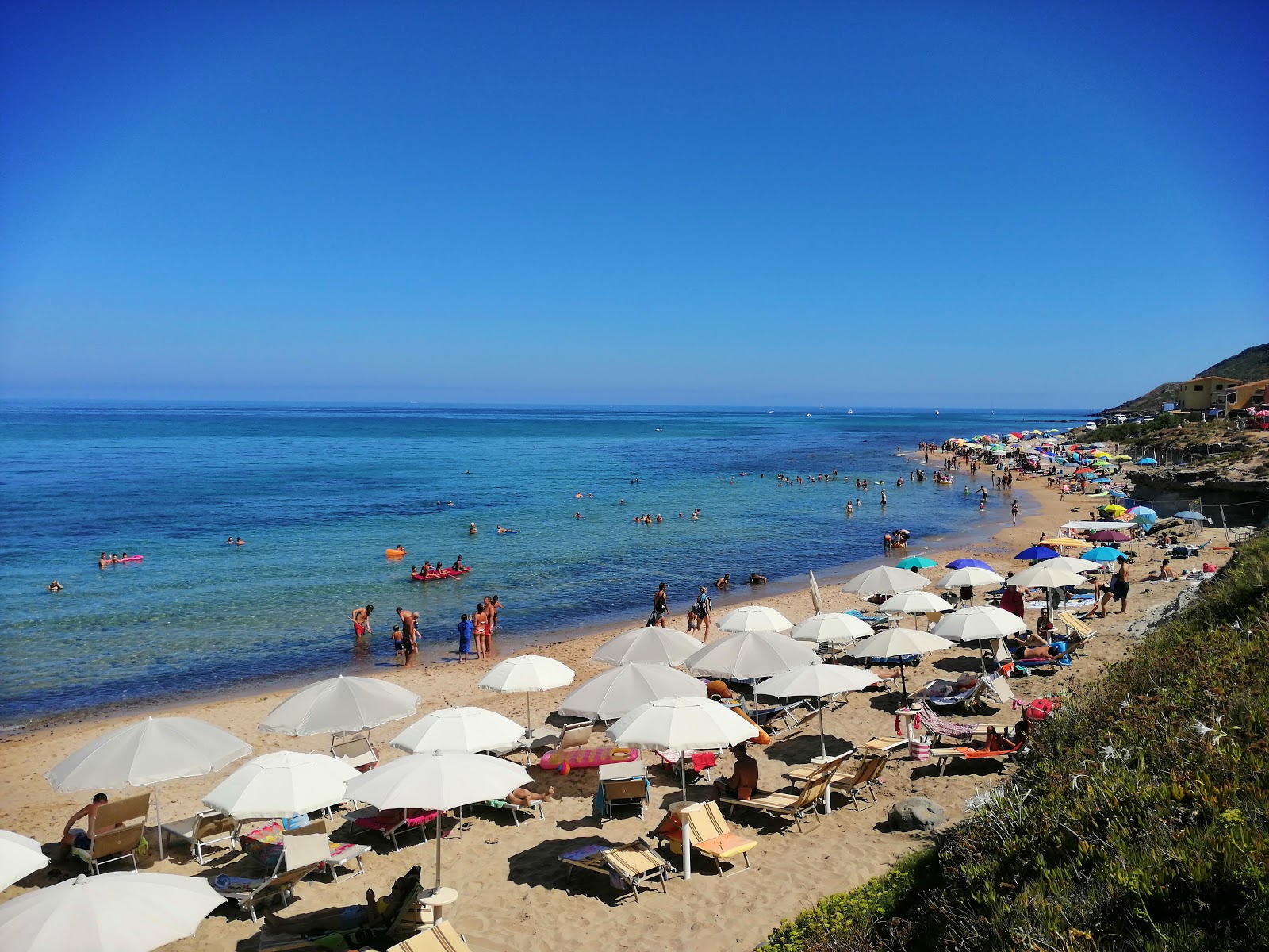 Foto van Spiaggia lu Bagnu met turquoise puur water oppervlakte