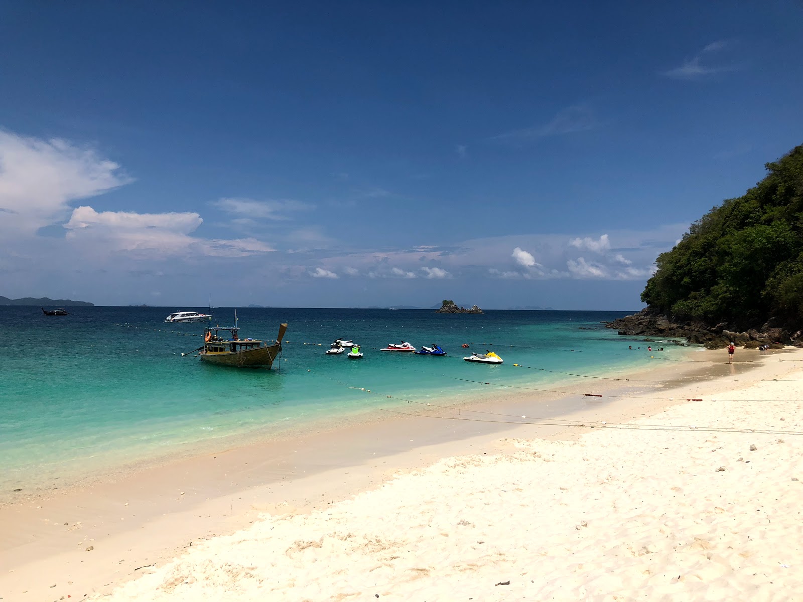 Valokuva Naka Noi Island Beachista. pinnalla kirkas hiekka:n kanssa