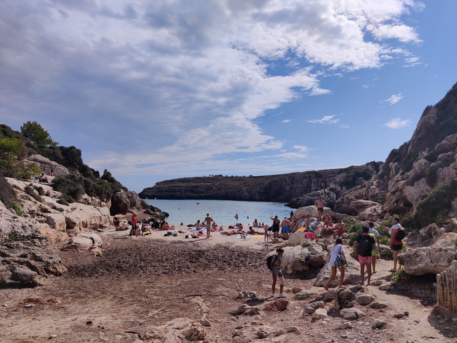 Foto av Cala Binidali med blå rent vatten yta