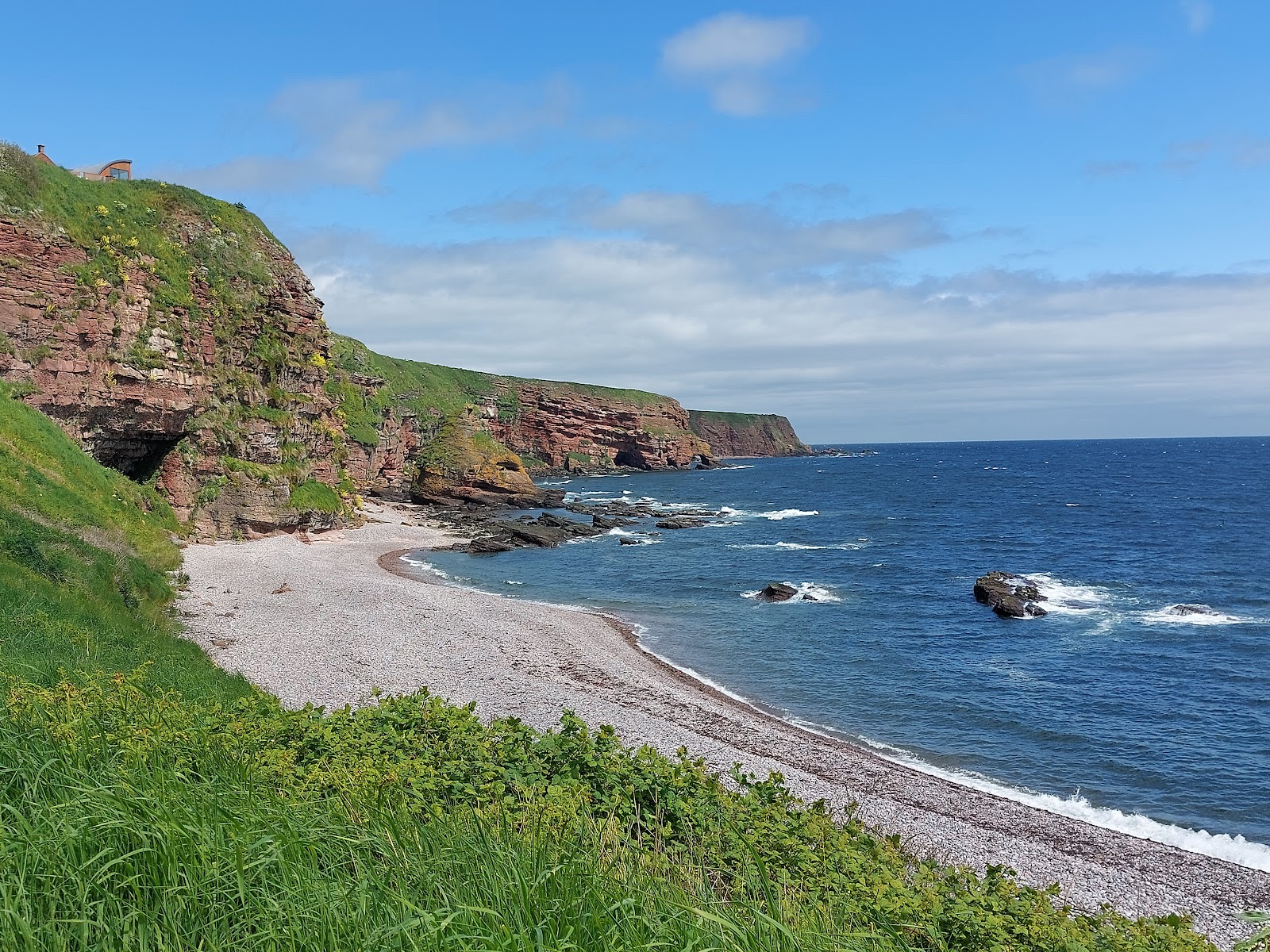 Foto di Auchmithie Beach con una superficie del ciottoli grigi