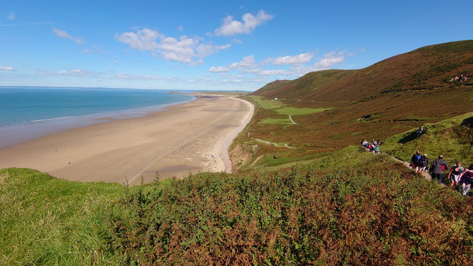 Photo of Rhossili bay beach with blue pure water surface