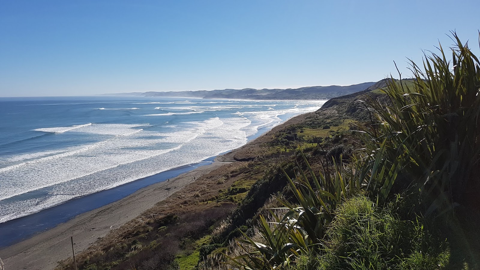 Foto av Ngarunui Beach omgiven av berg