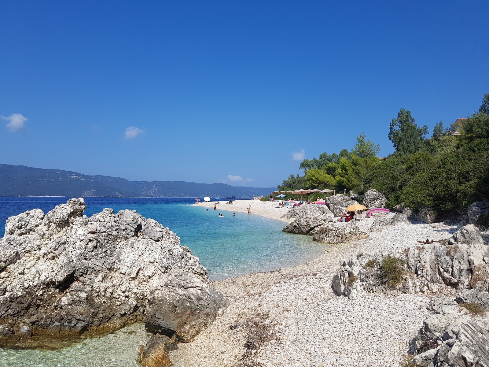 Foto von Aspros Gialos II Strand mit kleine, beiger kiesel Oberfläche