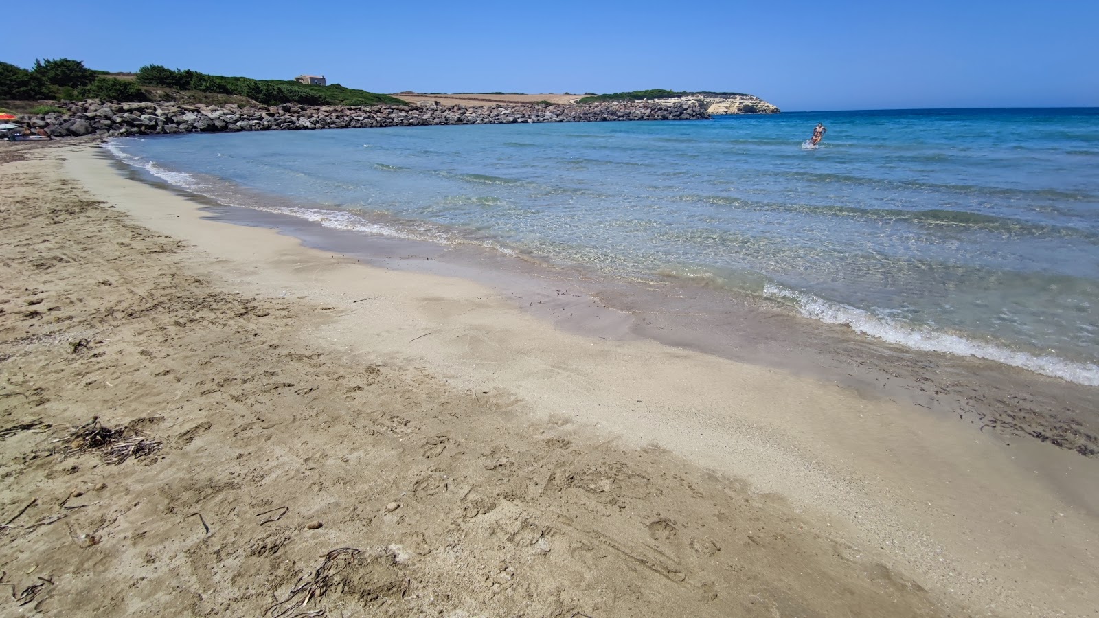 Valokuva Spiaggia Di Is Benasista. pinnalla kirkas hiekka:n kanssa