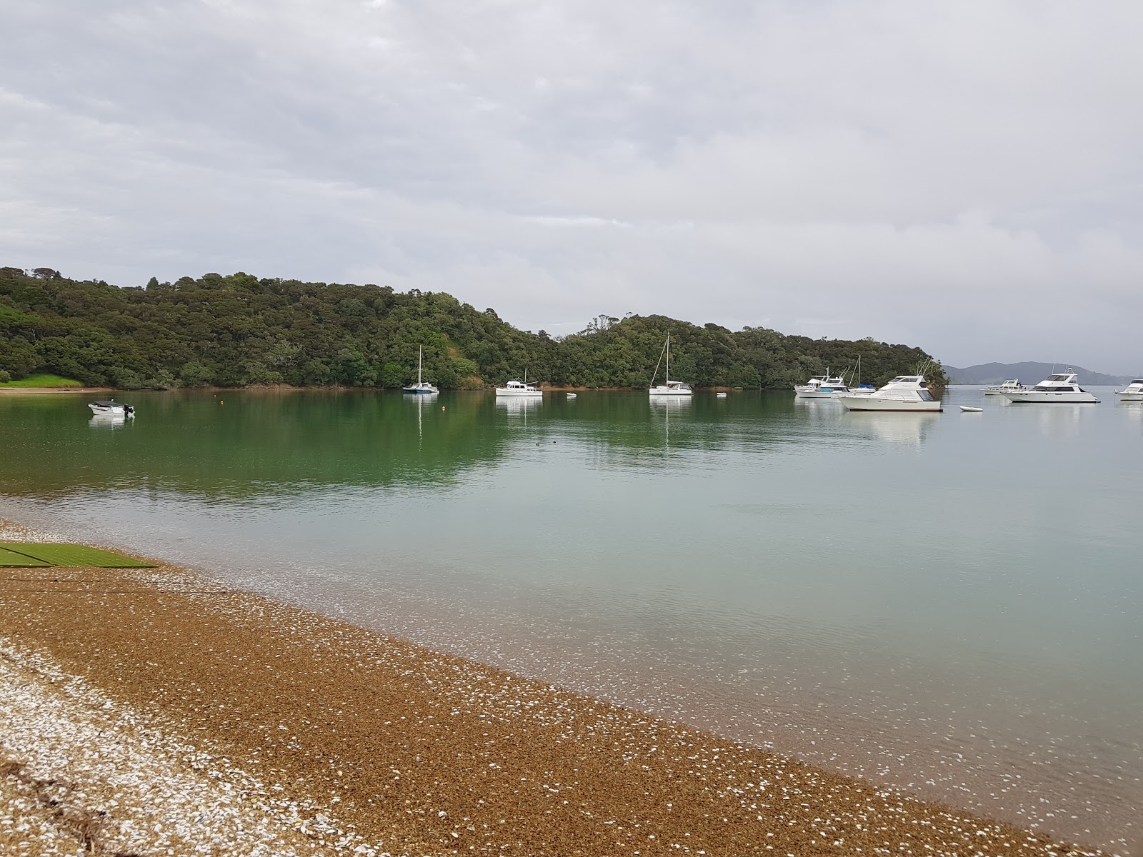 Fotografie cu Opunge Cove Beach cu o suprafață de nisip negru și pietricele