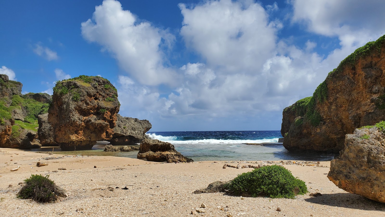 Foto de San Juan Beach com areia clara e rochas superfície