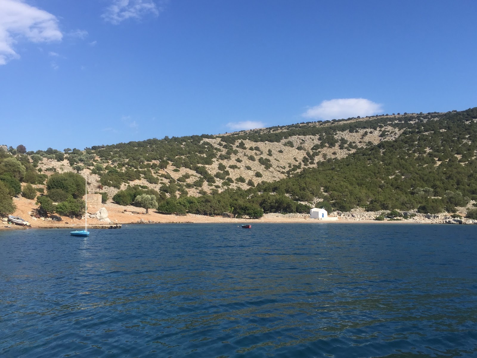 Dokos Ag.Nikolaos'in fotoğrafı siyah kum ve çakıl yüzey ile