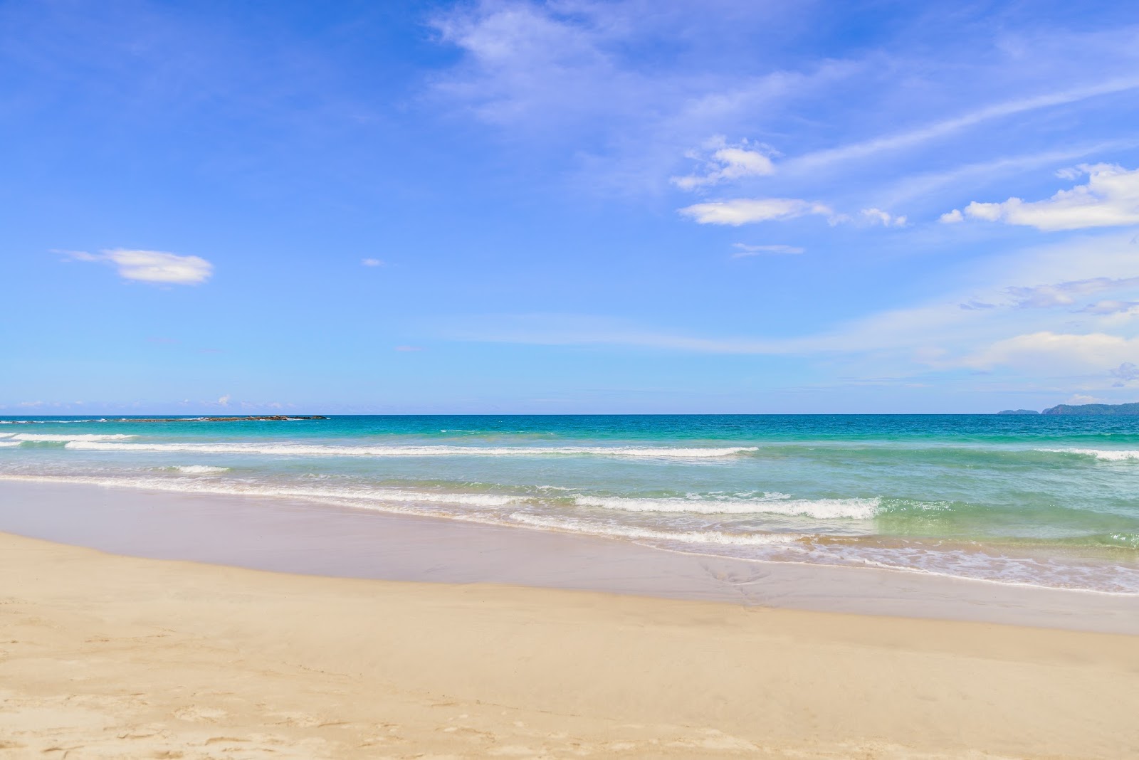 Foto av Manlipien Beach med rymlig strand