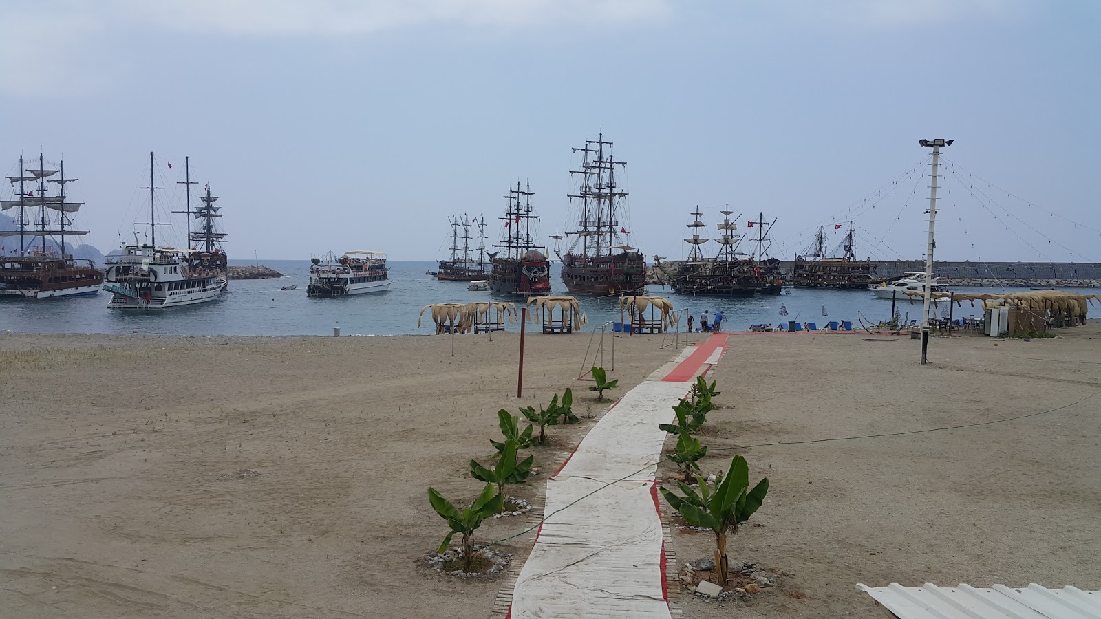 Φωτογραφία του Dinek beach II με γκρίζα άμμος επιφάνεια