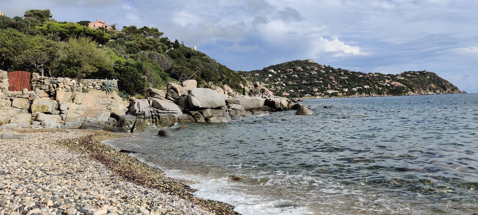 Foto von Caletta di Baccu Mandara von Klippen umgeben