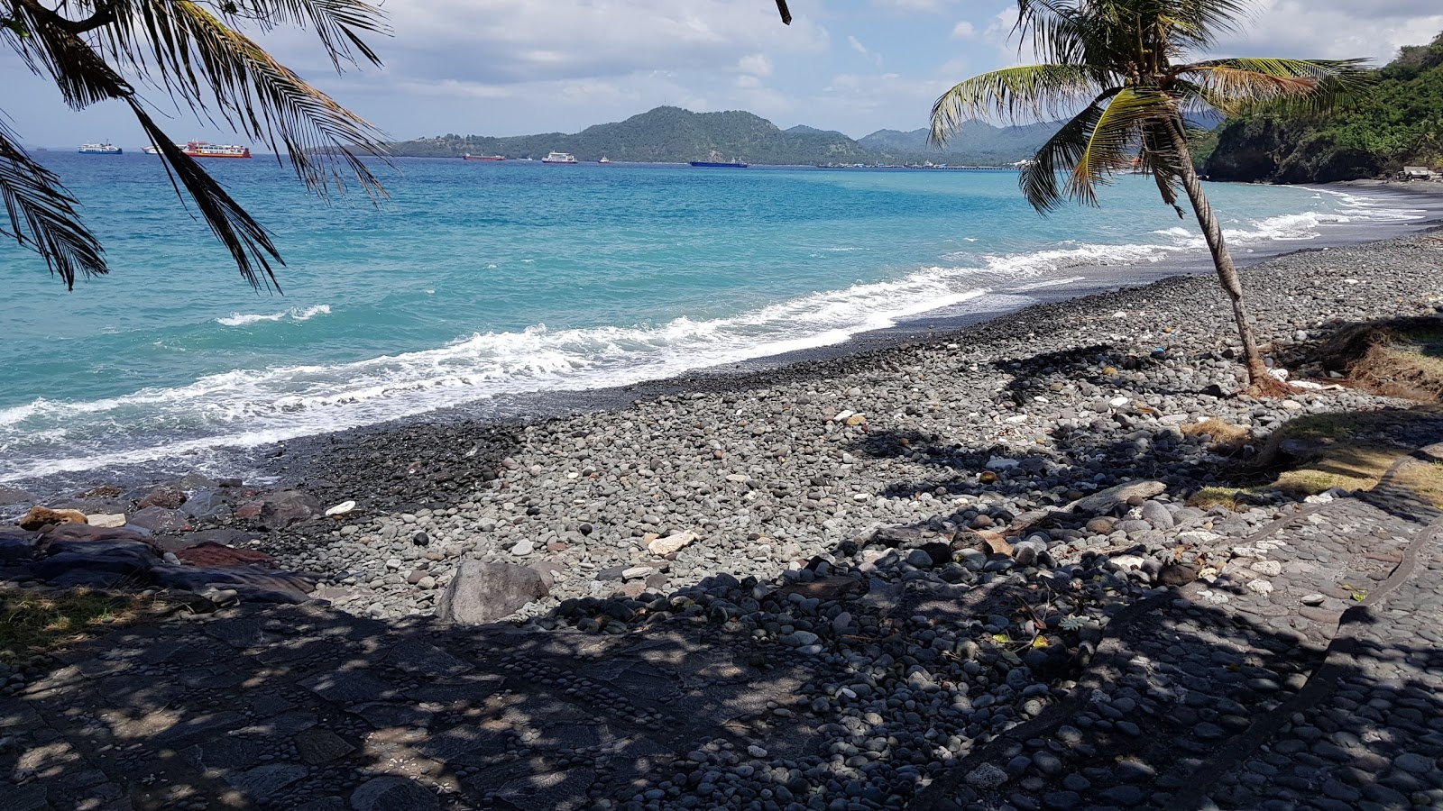 Foto de Buitan Beach con agua cristalina superficie