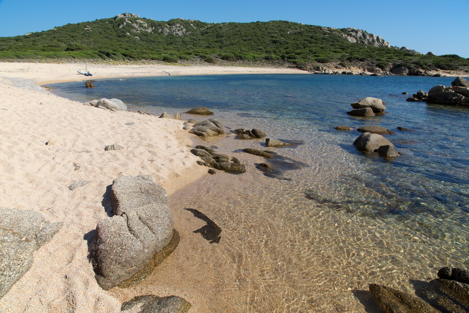 Foto di Cala di Conca II con una superficie del sabbia beige