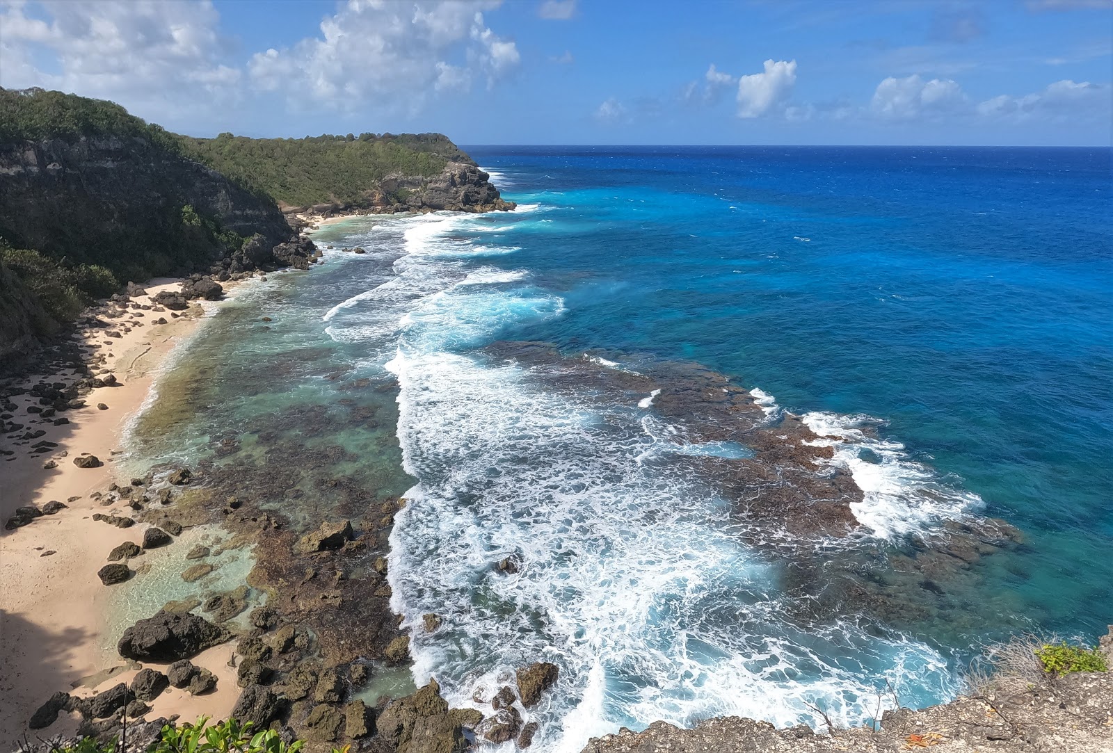 Photo de Anse A BURGAUT avec sable brillant et rochers de surface