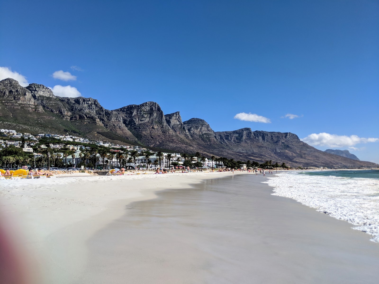 Foto di Camps Bay beach con una superficie del sabbia beige fine