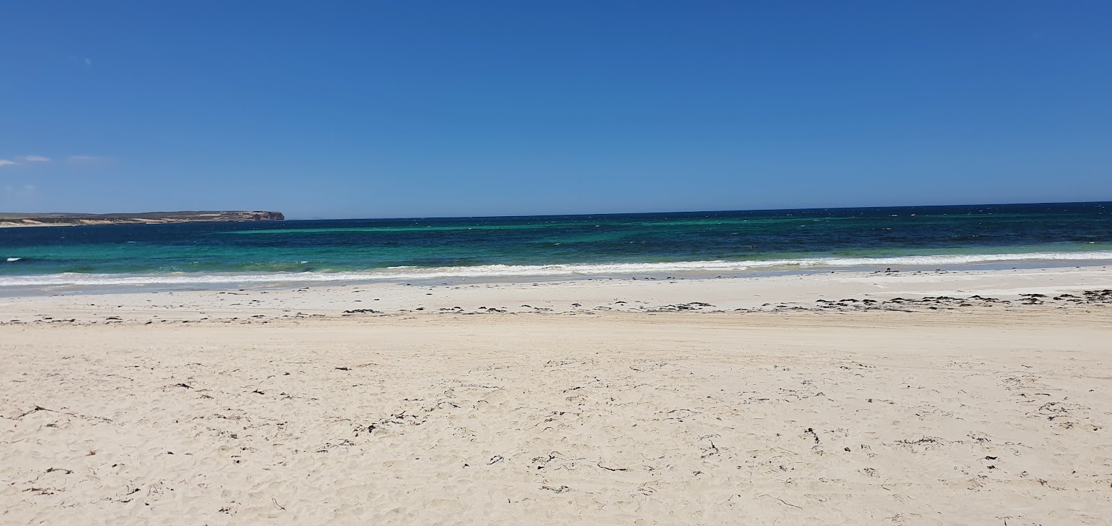 Foto av Sheringa Beach med blå rent vatten yta