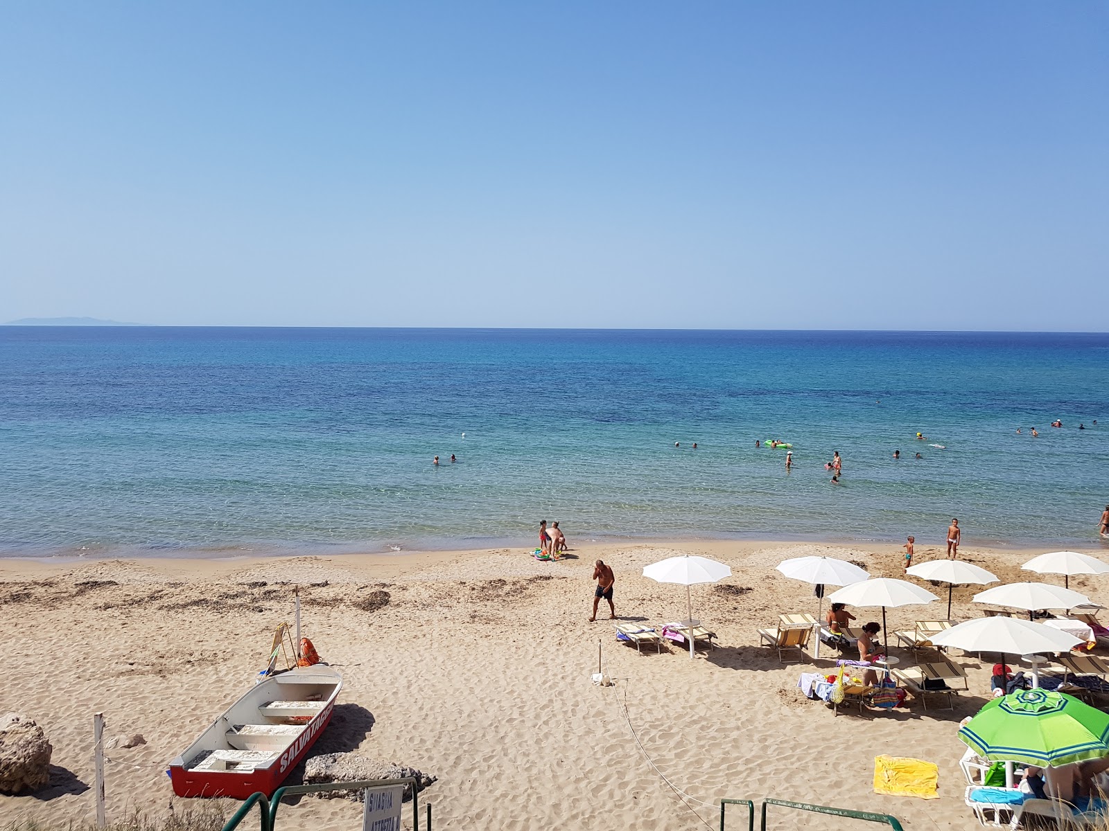 Foto von Spiaggia lu Bagnu mit beiger sand & steine Oberfläche