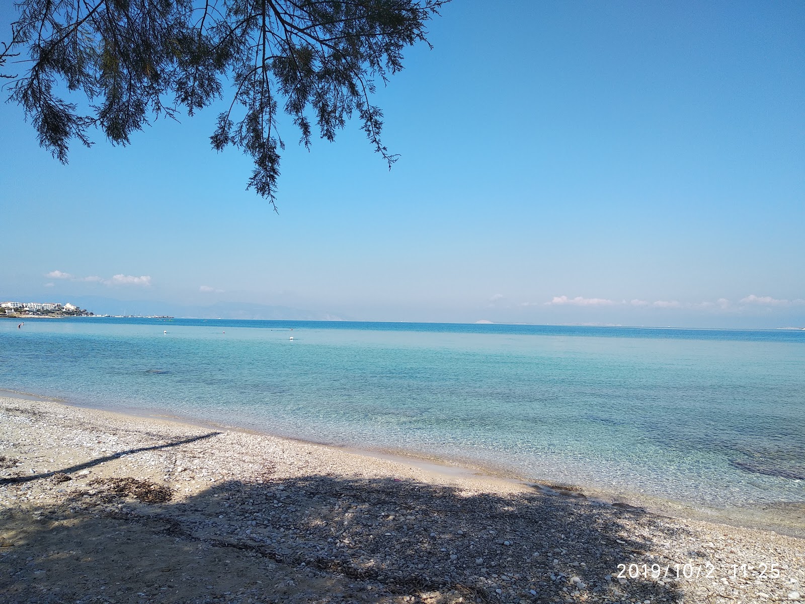 Foto av Paralia Skalas II med musta hiekka ja kivi yta