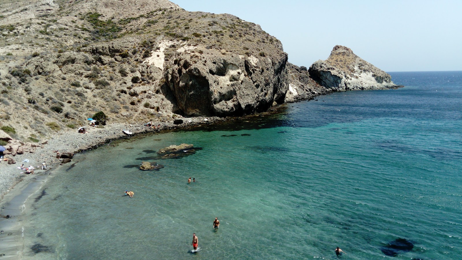 Foto di Cala Higuera con una superficie del ciottoli marroni