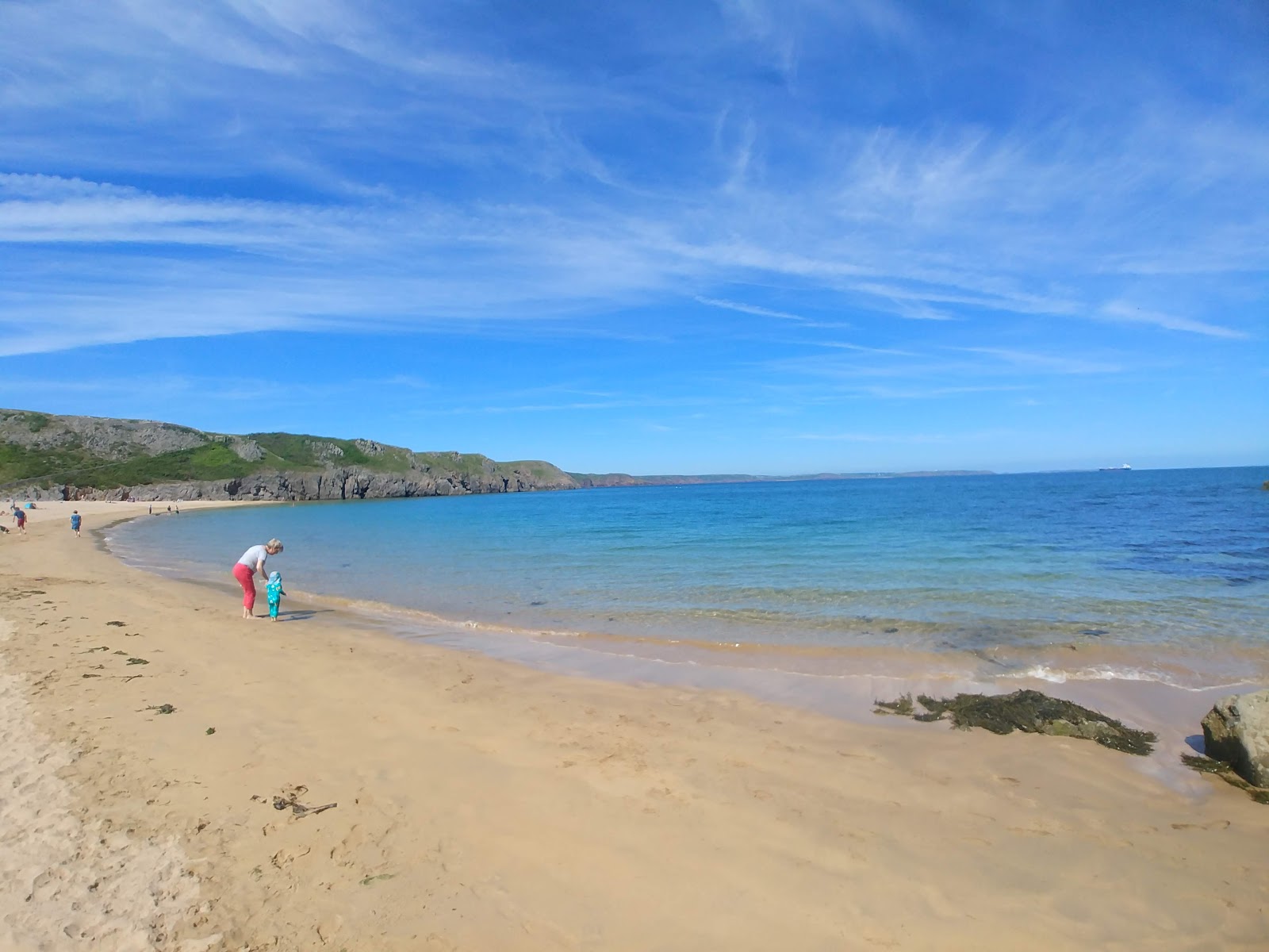 Barafundle Bay beach的照片 带有蓝色纯水表面