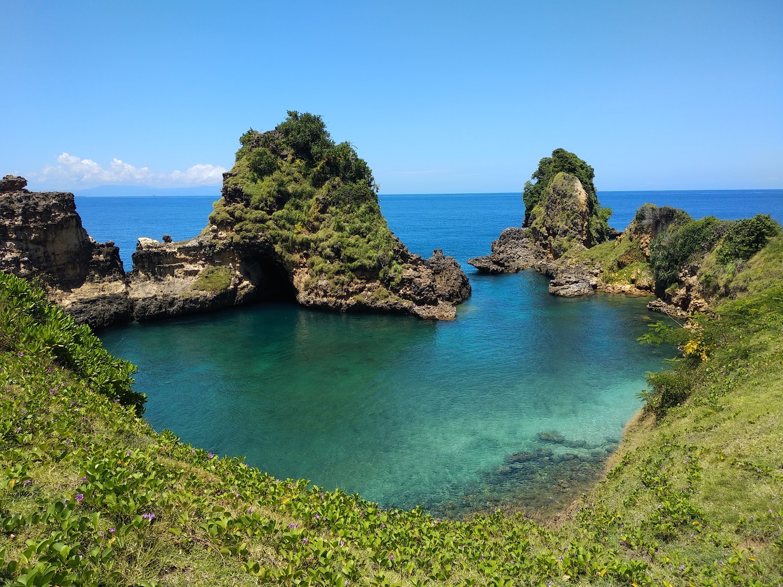 Foto di Sari Goang Beach con una superficie del sabbia beige e rocce