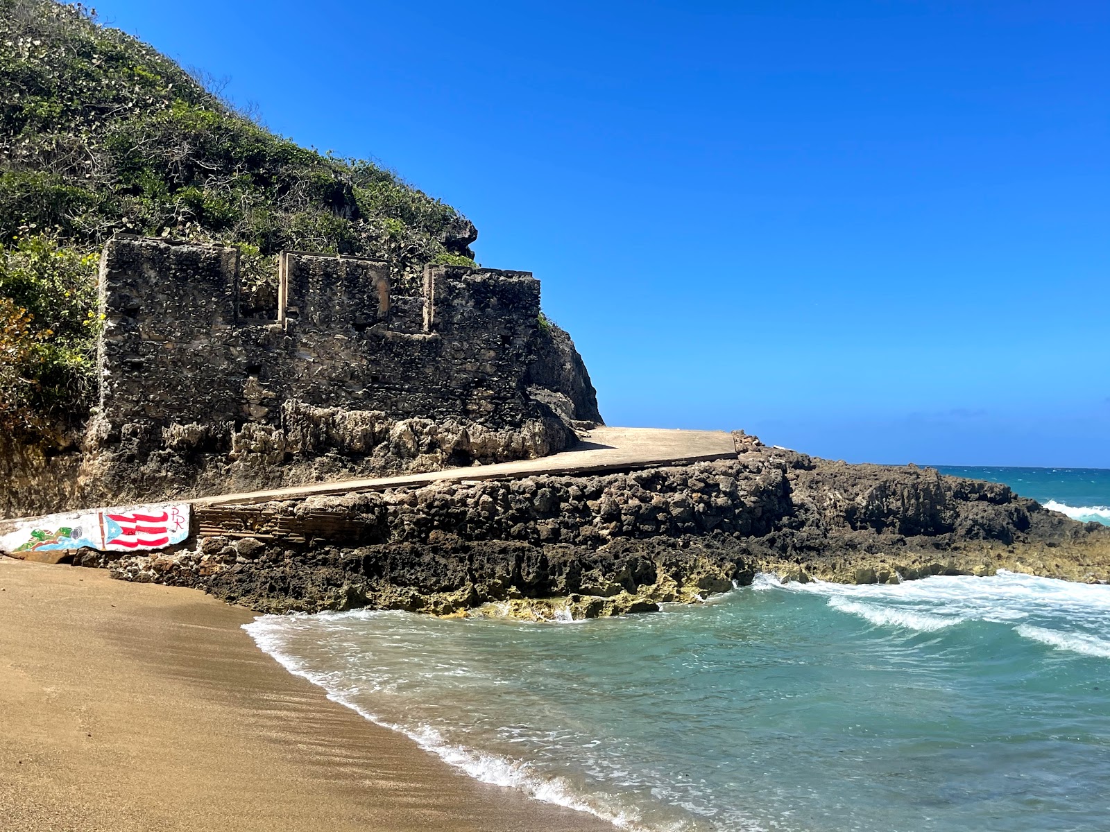 Foto de Playa Puerto Hermina apoiado por penhascos
