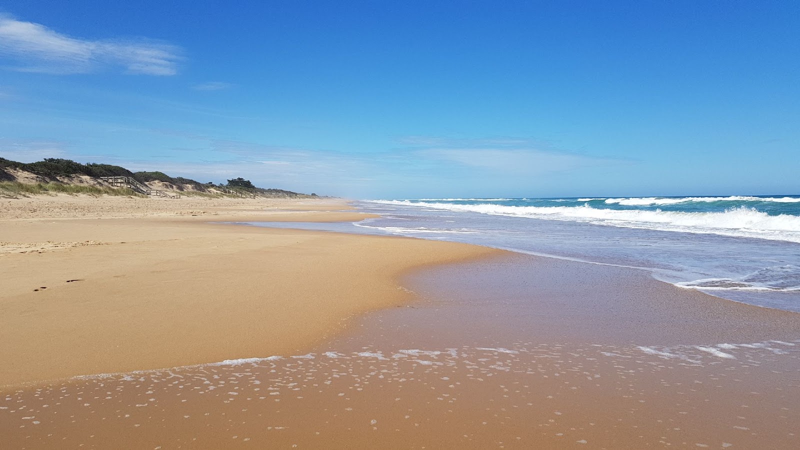 Foto de Mcloughlins Beach con arena beige superficie