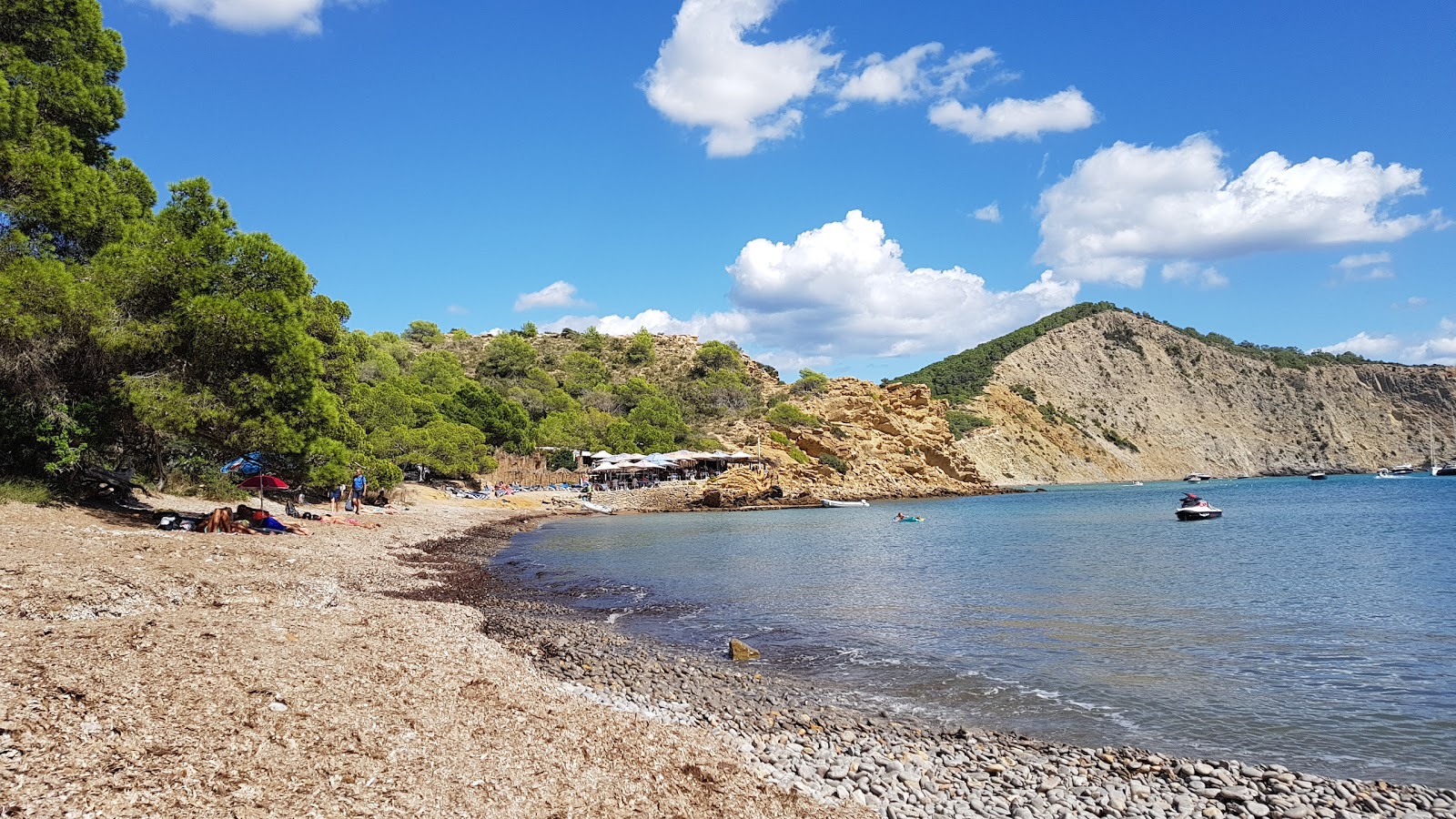 Foto di Playa Es Xarcu con una superficie del ciottoli grigi