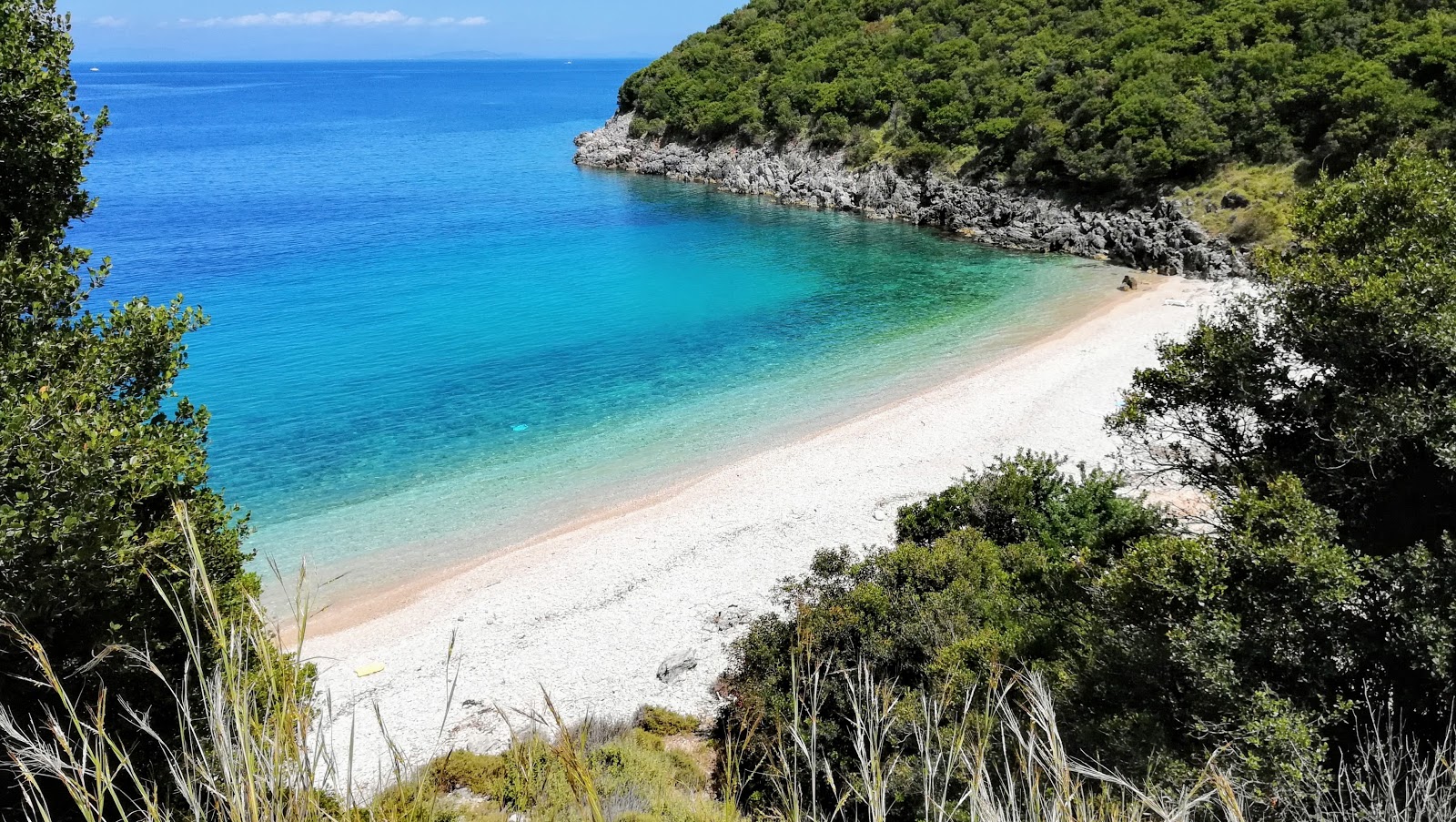 Fotografie cu Kaminia beach cu o suprafață de pietricele beige