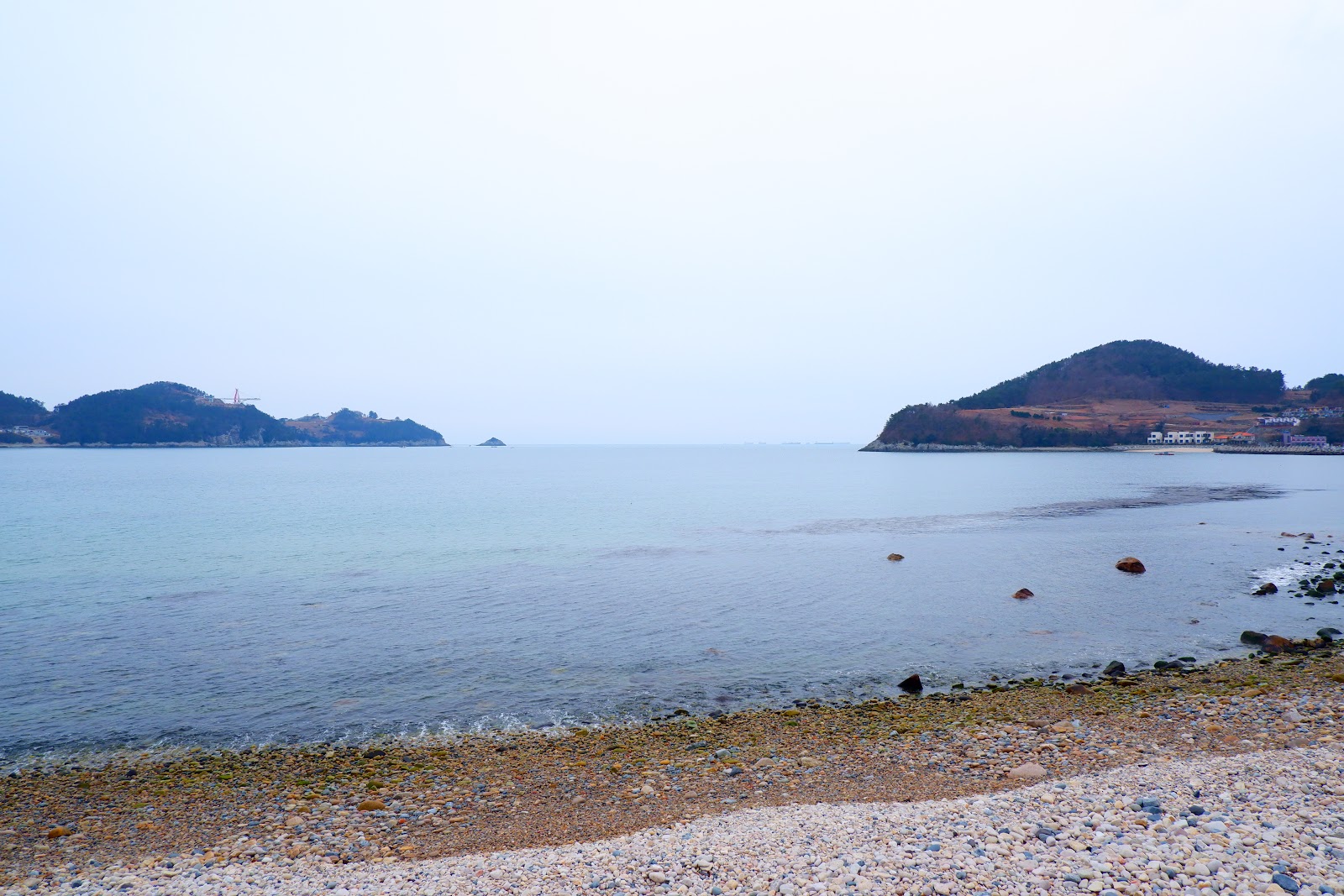 Zdjęcie Cheonha Beach z powierzchnią szary kamyk