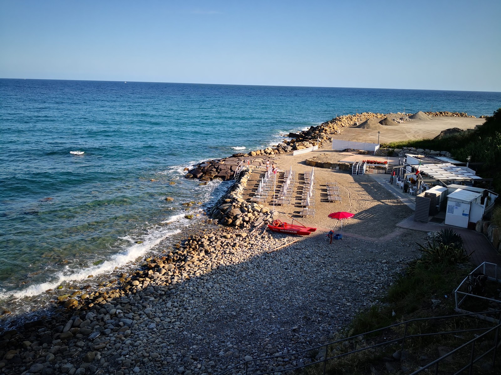 Foto af La Caletta beach med brun sten overflade