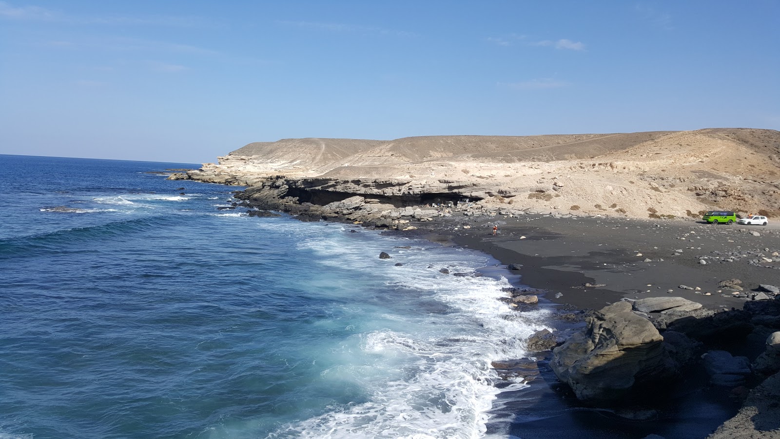 Fotografie cu Playa Negras cu o suprafață de nisip alb și roci