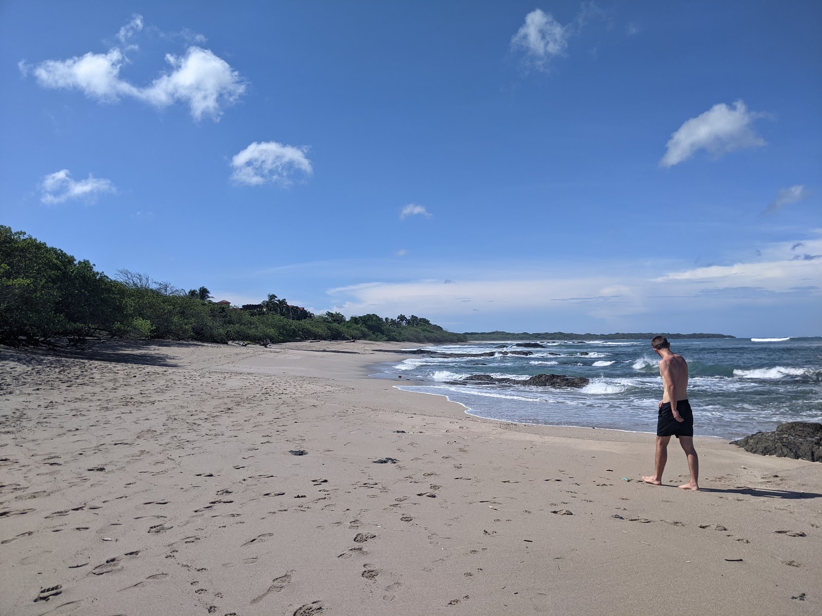 Foto di Playa Langosta con una superficie del sabbia beige e rocce