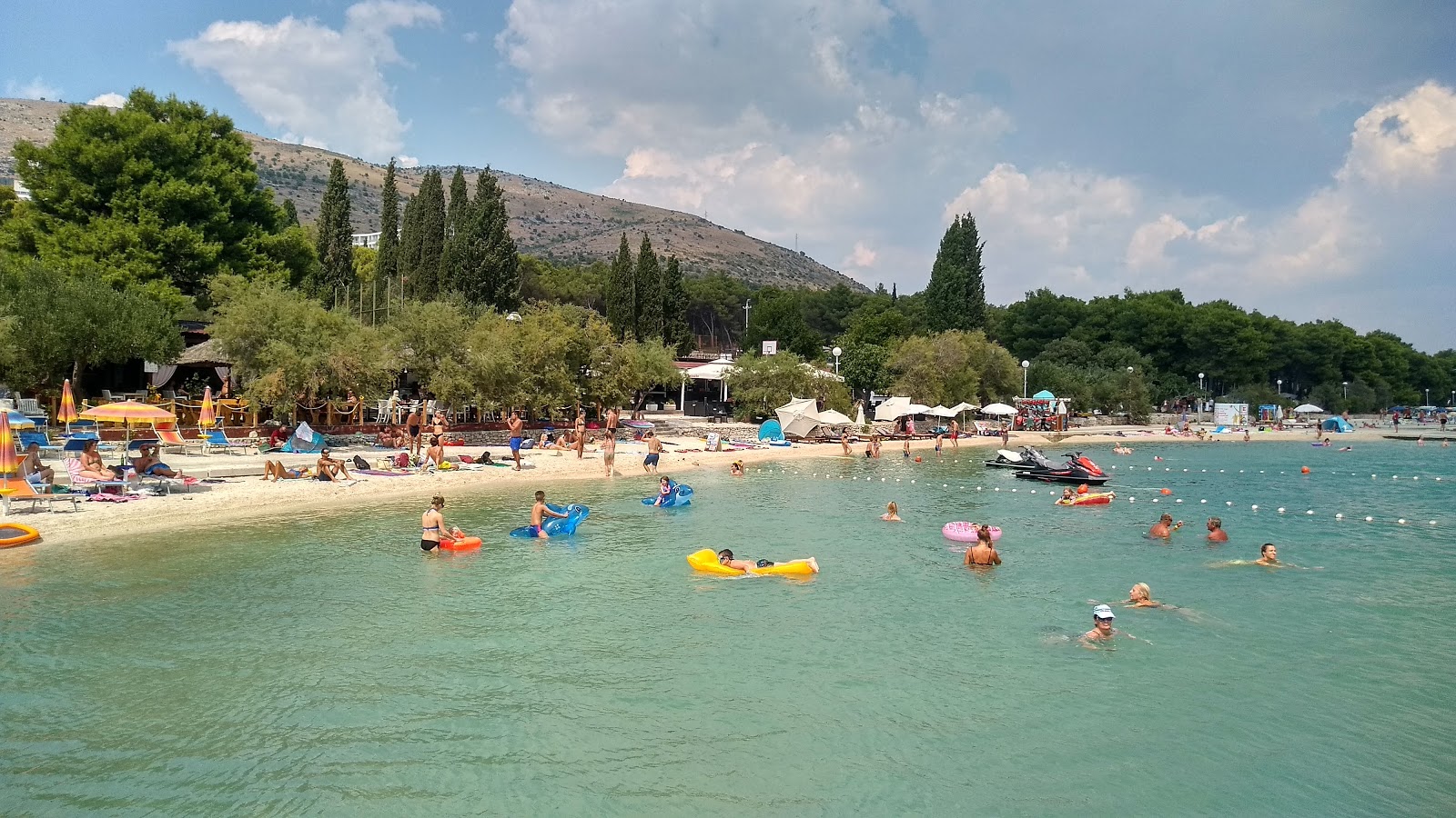 Foto af Medena beach bakket op af klipperne