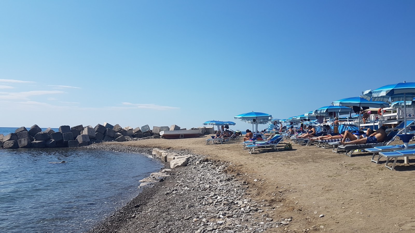 Photo of Bussentino port beach with brown pebble surface