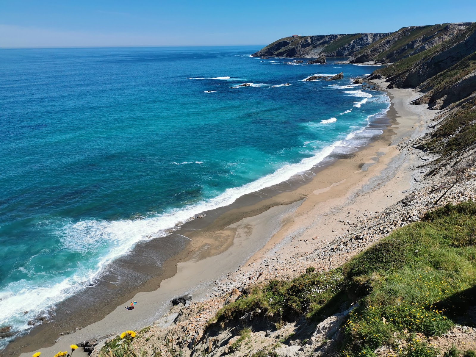 Foto av Playa de Vallina med grå sand och stenar yta