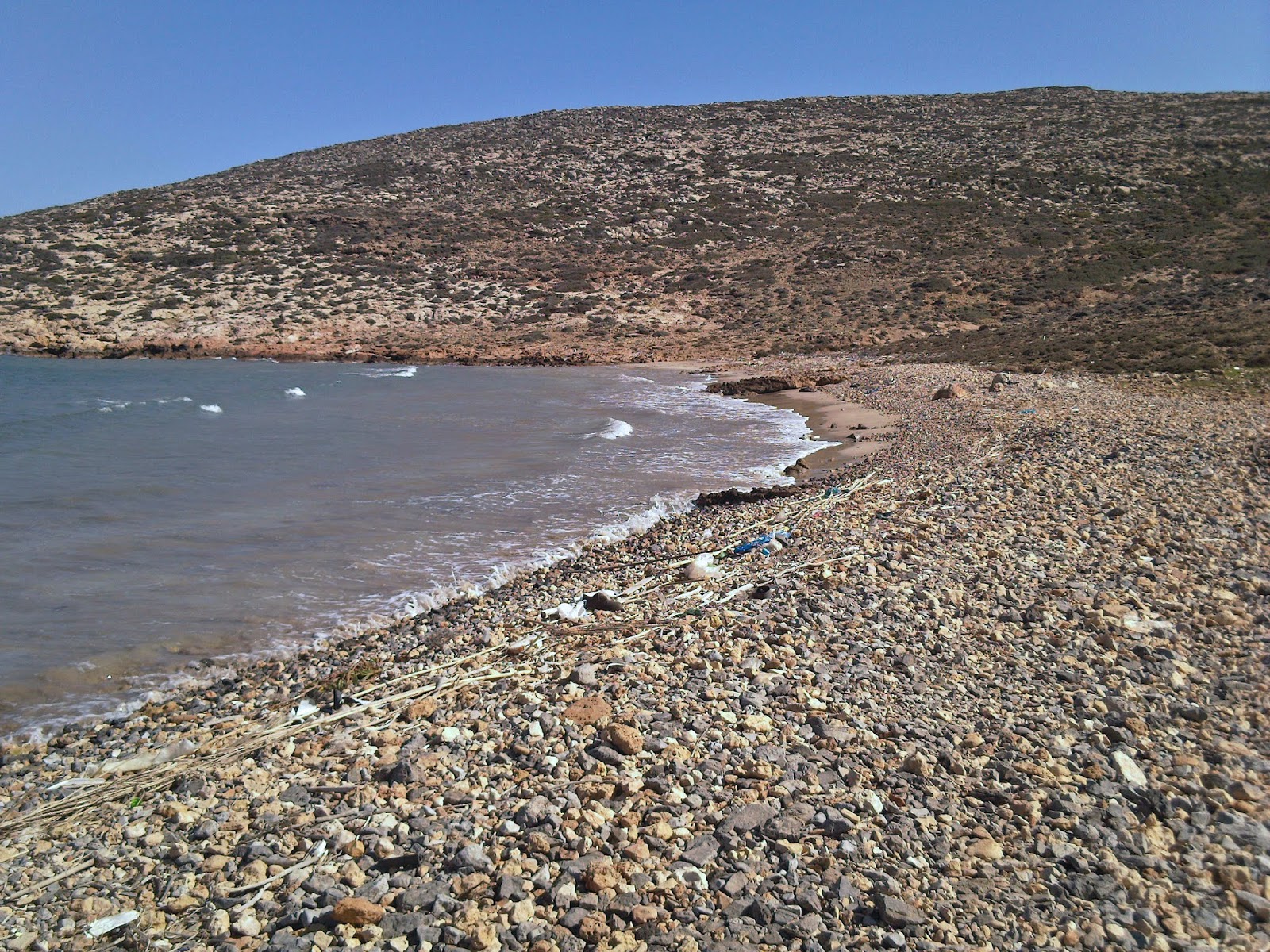 Photo of Skariá beach with brown sand &  rocks surface