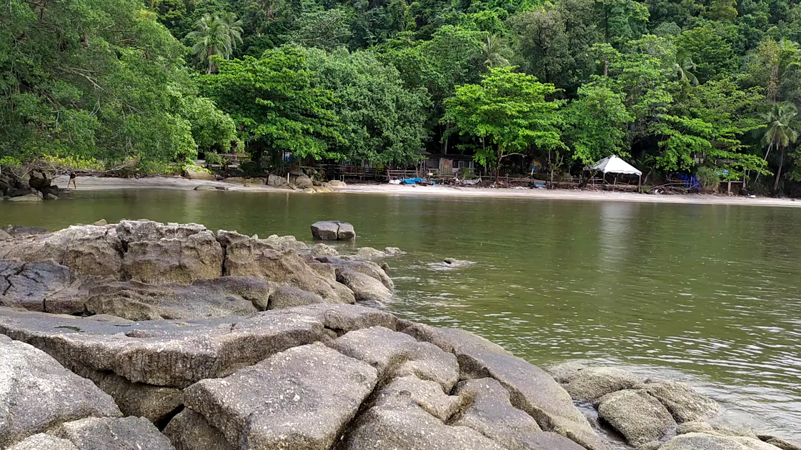 Fotografija Tanjung Asam Beach obkrožen z gorami