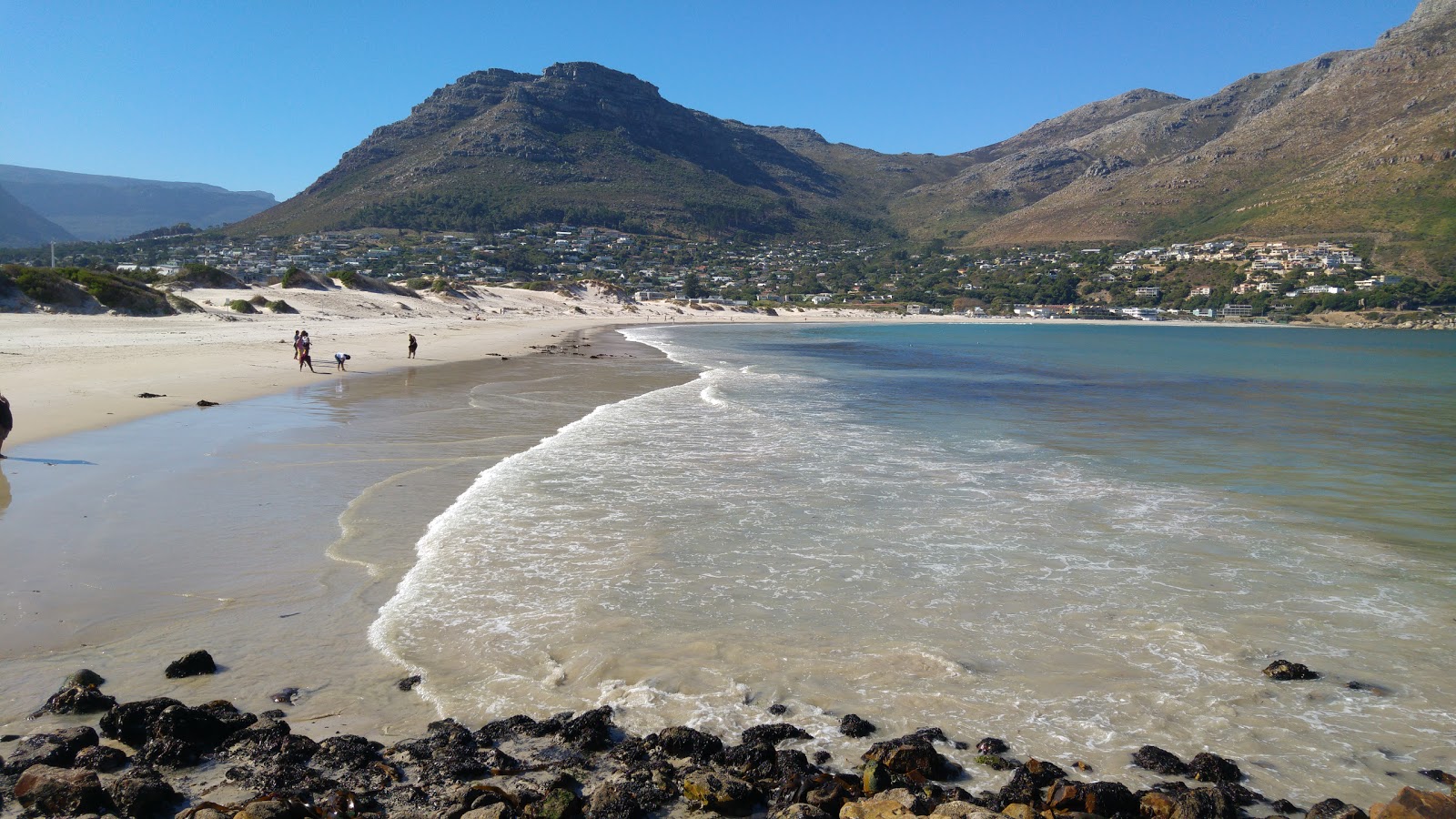 Photo of Hout Bay beach backed by cliffs