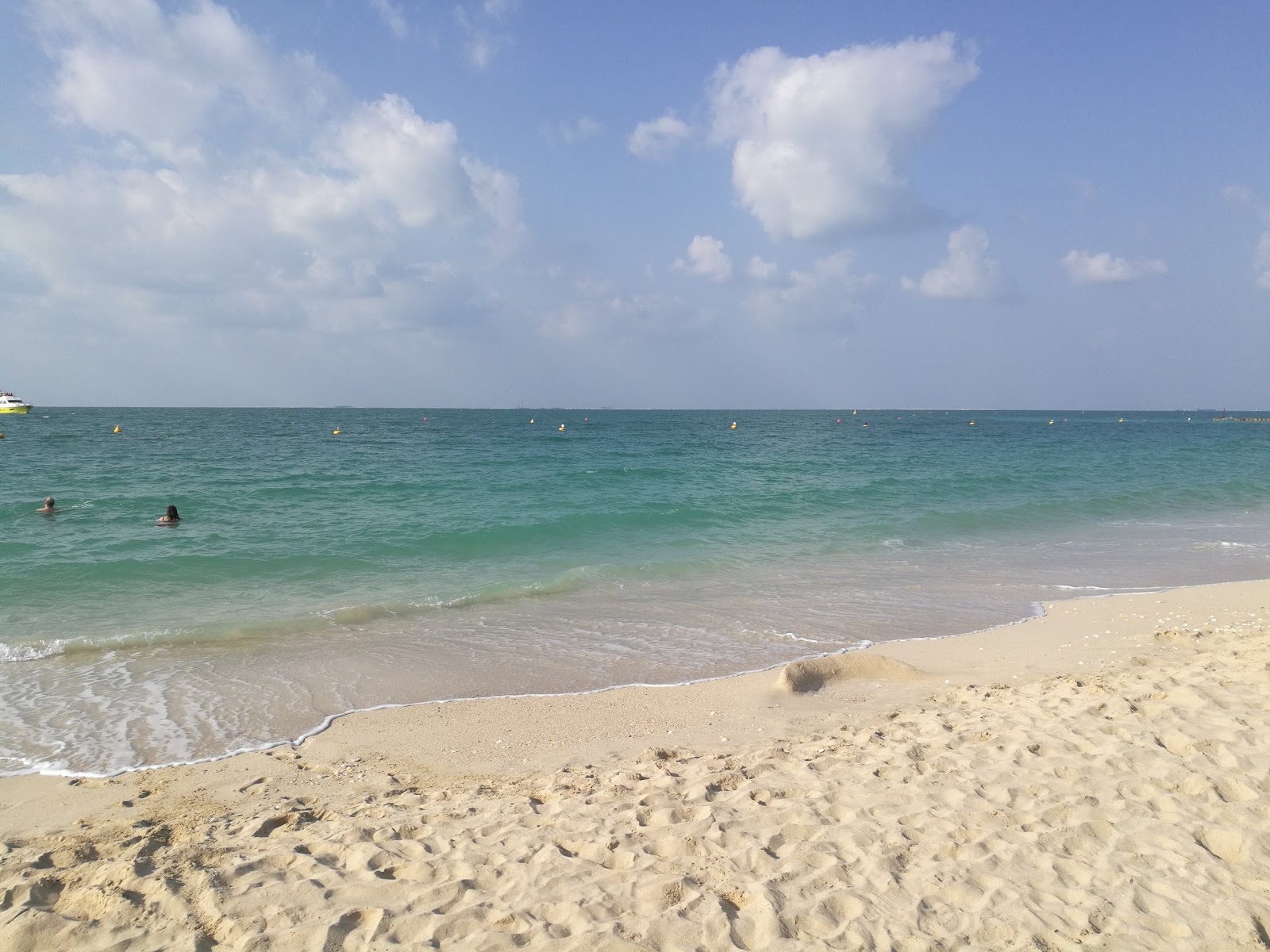 Umm Suqeim beach'in fotoğrafı turkuaz saf su yüzey ile