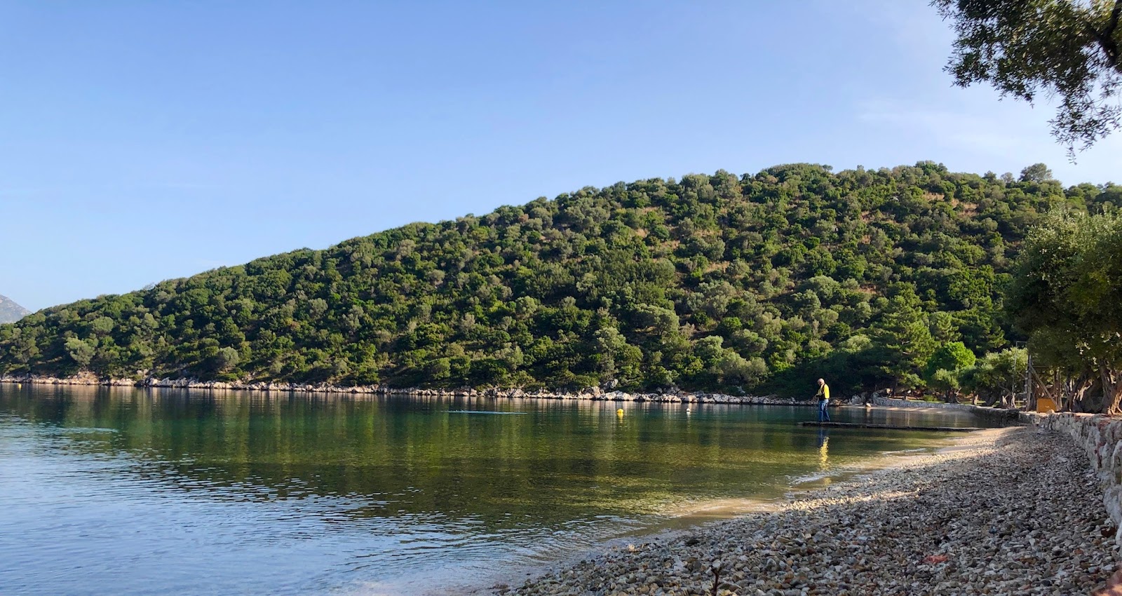 Foto von Dexa Strand von Klippen umgeben