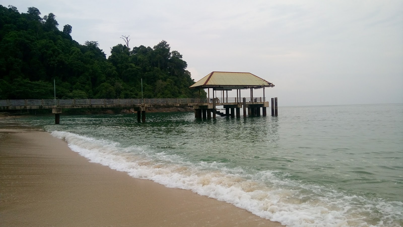 Foto von Ketapang Beach von Klippen umgeben