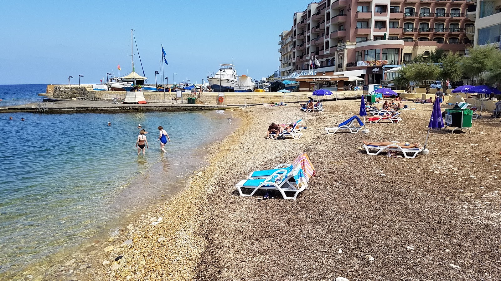Foto di Marsalforn Beach con una superficie del piccoli ciottoli beige