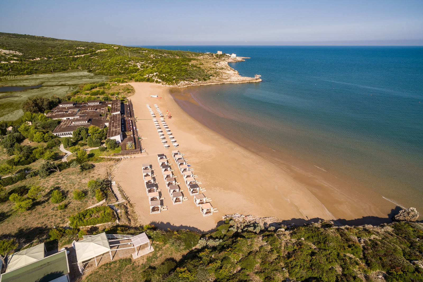 Photo of Baia del Gusmay with brown fine sand surface