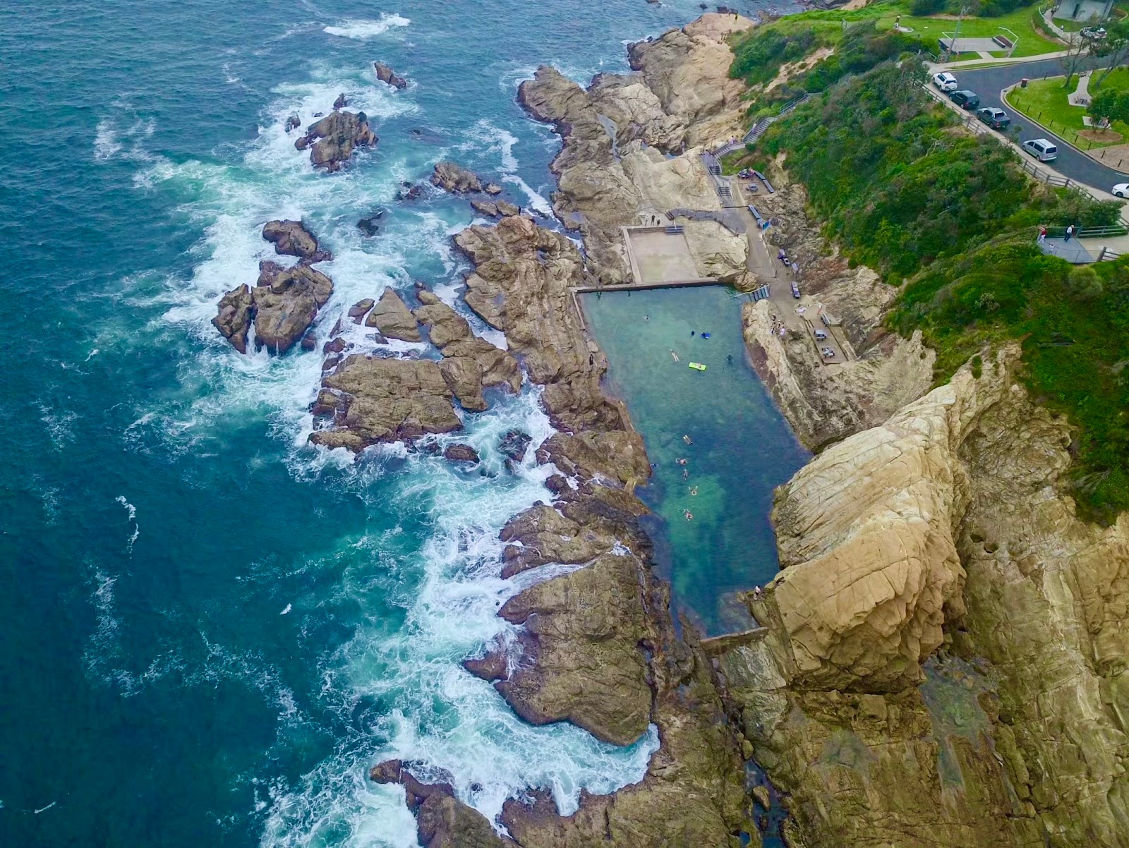 Foto af Bermagui Blue Pool bakket op af klipperne