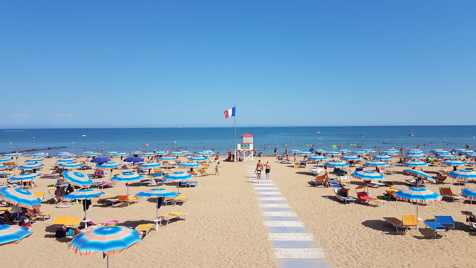 Photo of Lignano beach with turquoise pure water surface