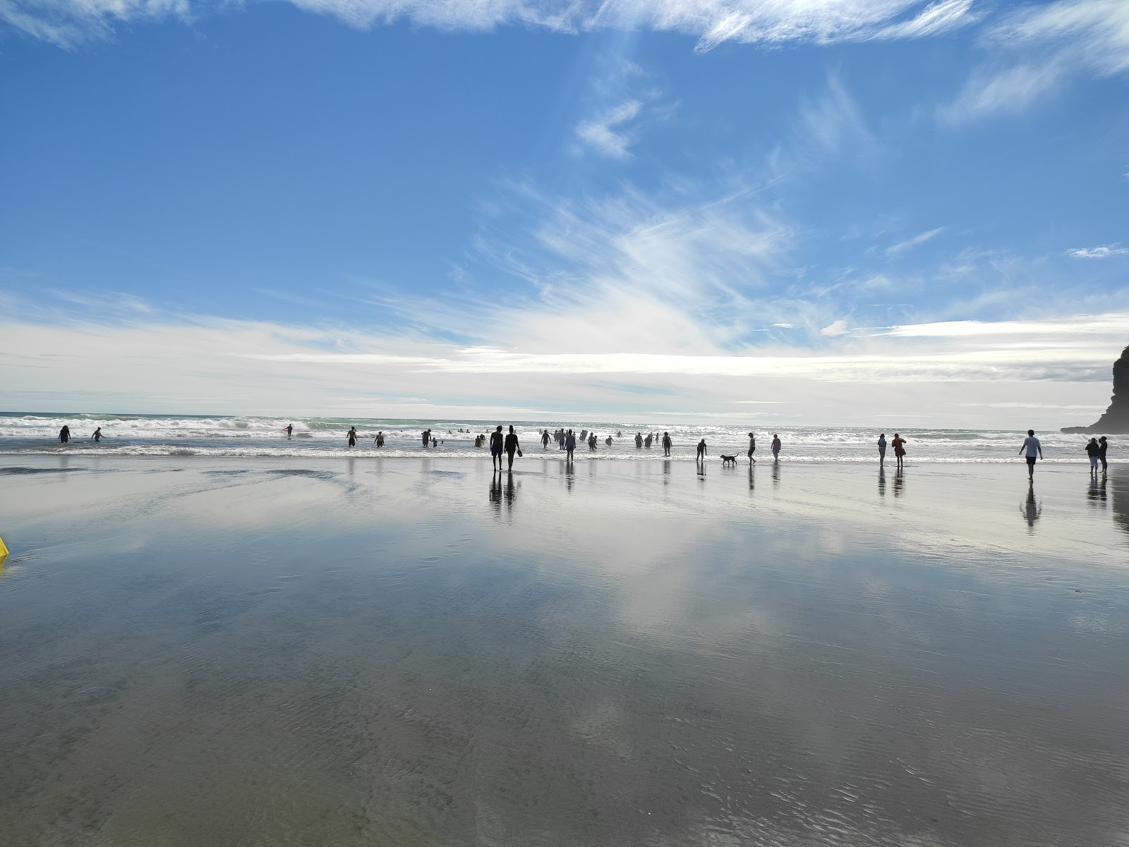 Foto av Te Henga Beach omgiven av klippor