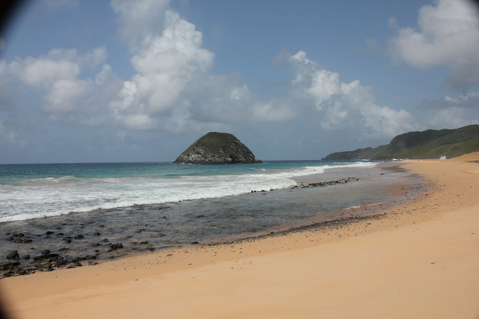 Foto af Praia do Sueste bakket op af klipperne