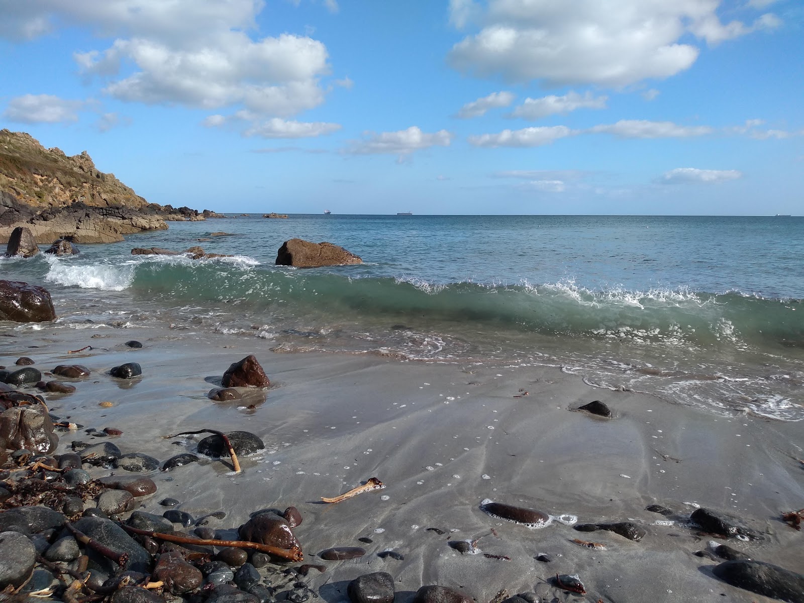 Valokuva Porthbeer Coveista. ympäröity vuorilla