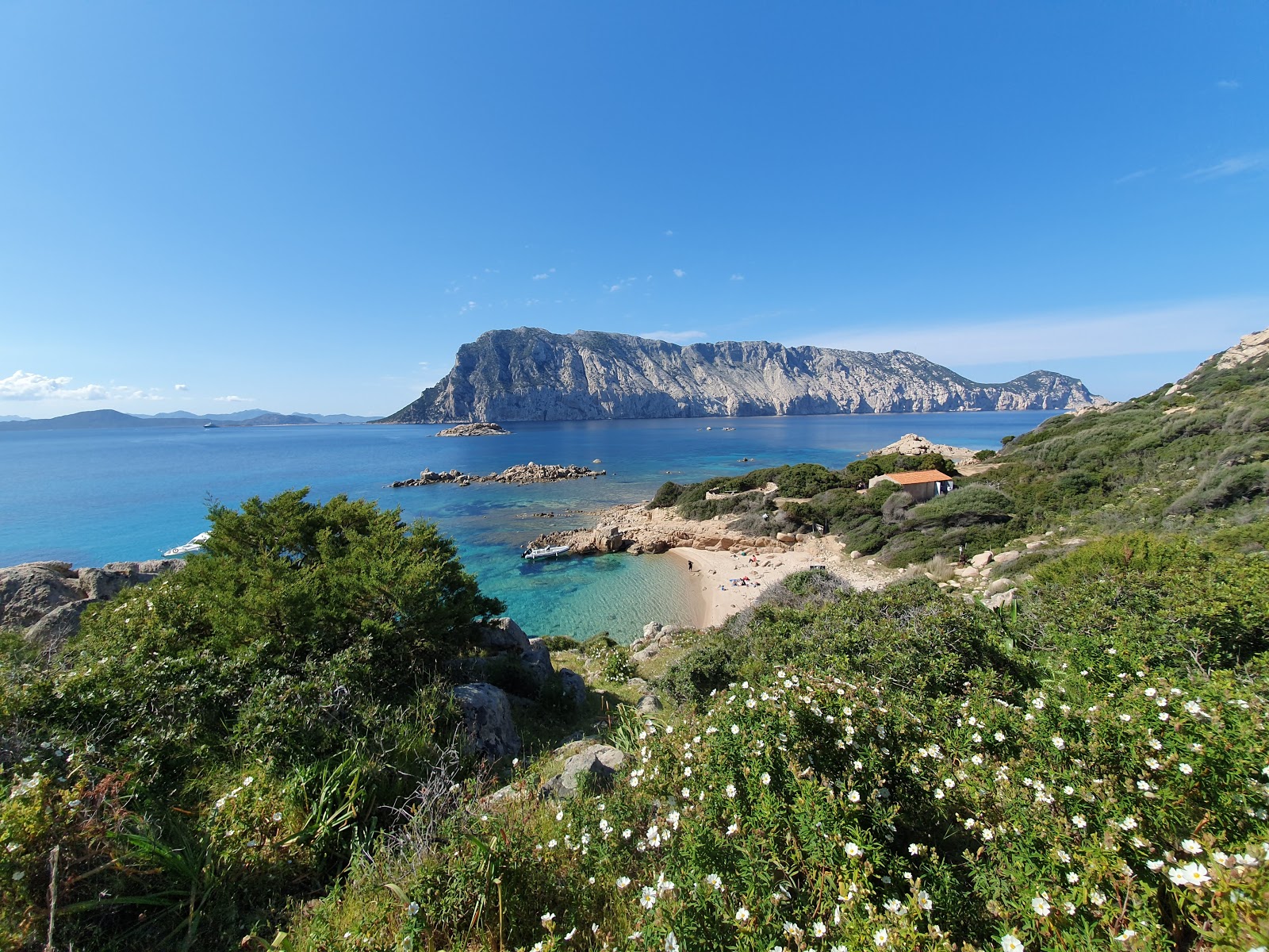 Foto di Spiaggia di Cala Spagnola con una superficie del sabbia beige e rocce